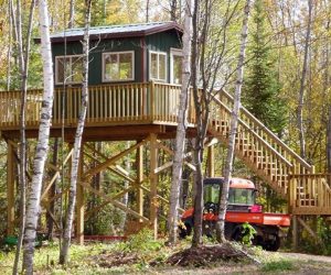 utv-parked-under-staircase-of-cabin-in-woods