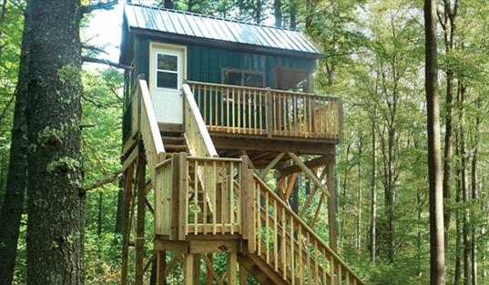 small-cabin-with-sleeping-loft-and-deer-blind-windows-tucked-in-forest